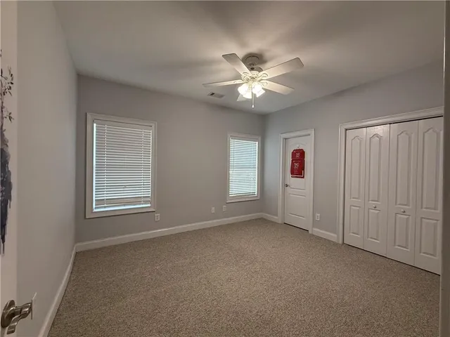 wooden floor in an empty room and a ceiling fan