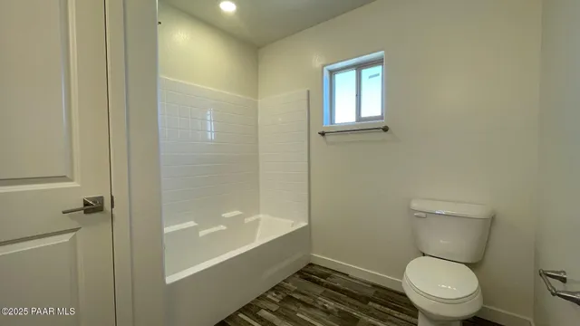 a white toilet sitting next to a bath tub