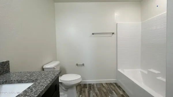 a bathroom with a granite countertop toilet and a bathtub
