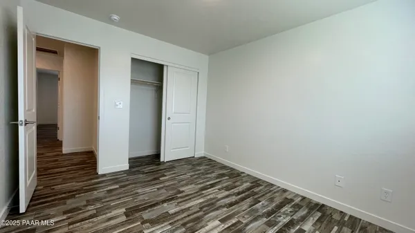 a view of a room with wooden floor and hallway