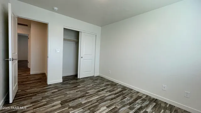 a view of a room with wooden floor and hallway