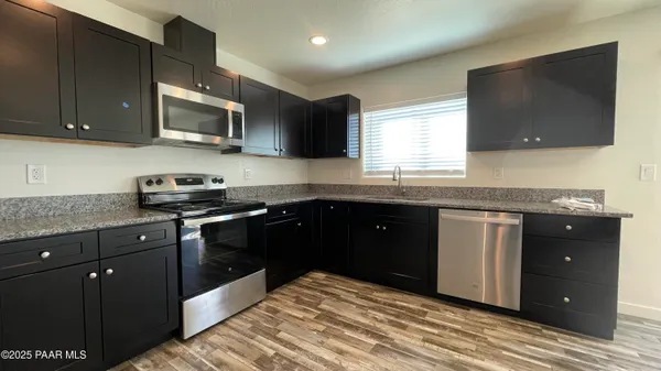 a kitchen with stainless steel appliances granite countertop a sink and a stove top oven