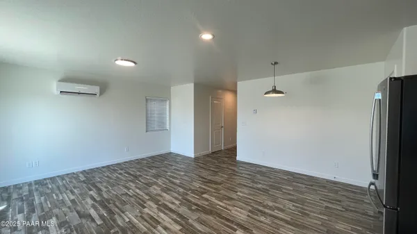 an empty room with wooden floor and a ceiling fan