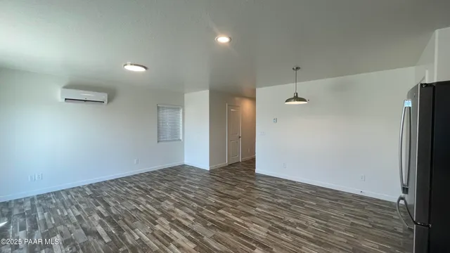 an empty room with wooden floor and a ceiling fan
