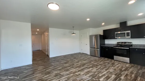 a kitchen with stainless steel appliances granite countertop a refrigerator and a stove top oven