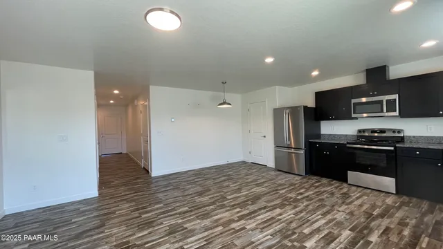 a kitchen with stainless steel appliances granite countertop a refrigerator and a stove top oven
