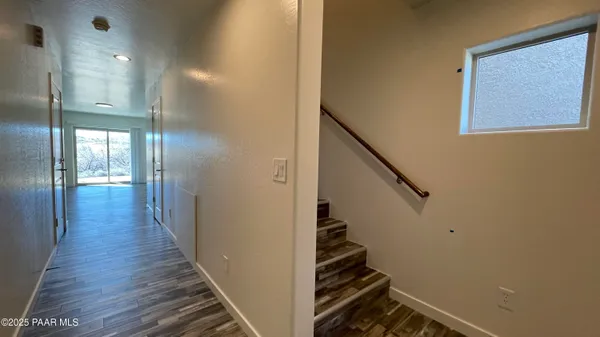 a view of a hallway with wooden floor and staircase