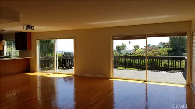 a view of a room with wooden floor and windows