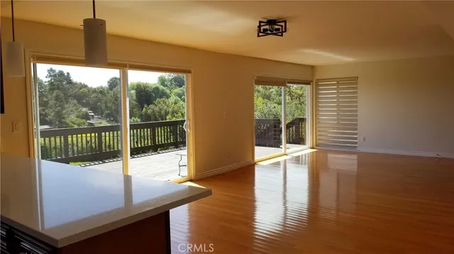 a view of a room with wooden floor and windows