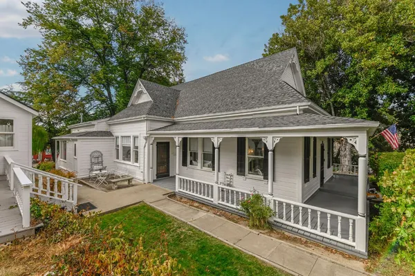 a living room with furniture chandelier and wooden floor
