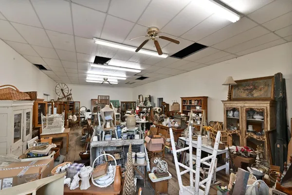 a backyard of a house with table and chairs and a large tree