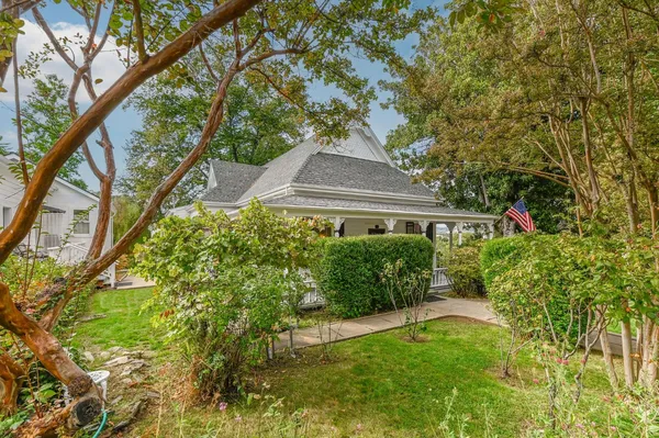 a view of a house with backyard and sitting area