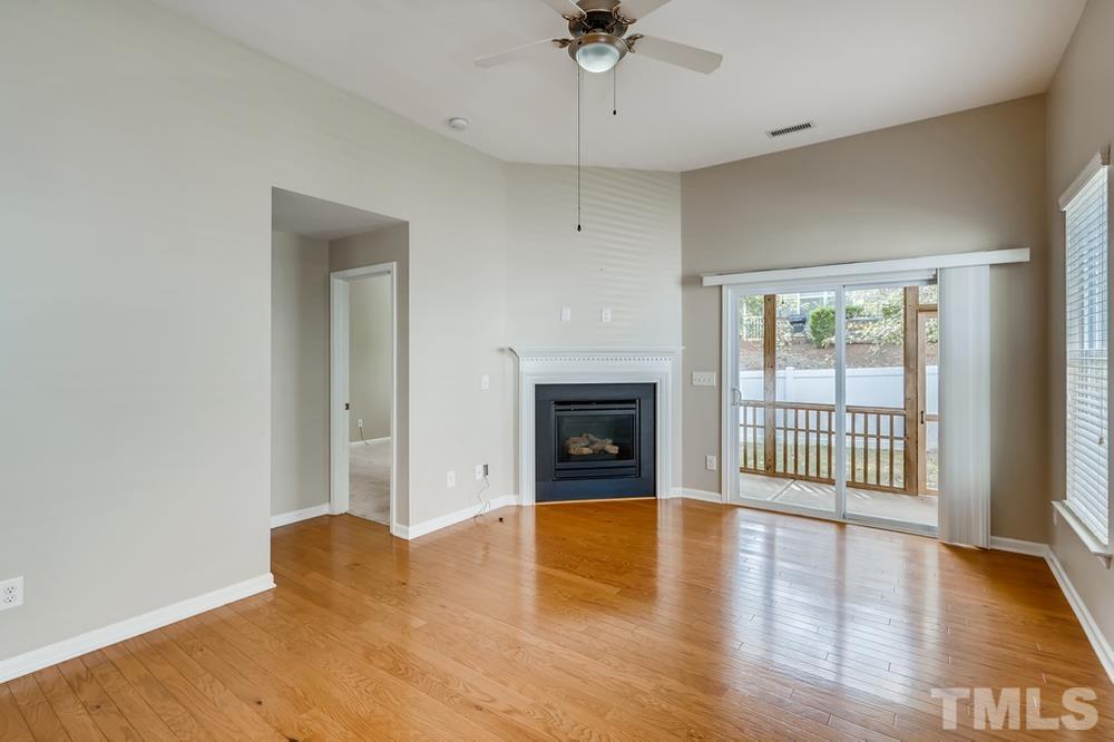 1258 Silver Beach Way Raleigh, NC 27606 - Photo 5 of 28 an empty room with wooden floor and fireplace