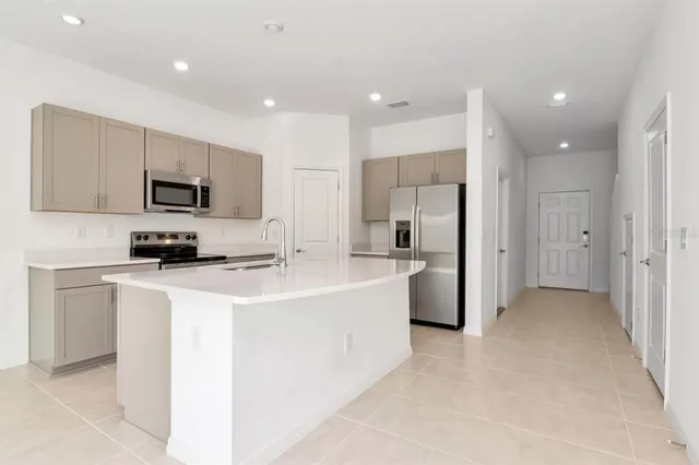 a kitchen with stainless steel appliances a refrigerator sink and microwave