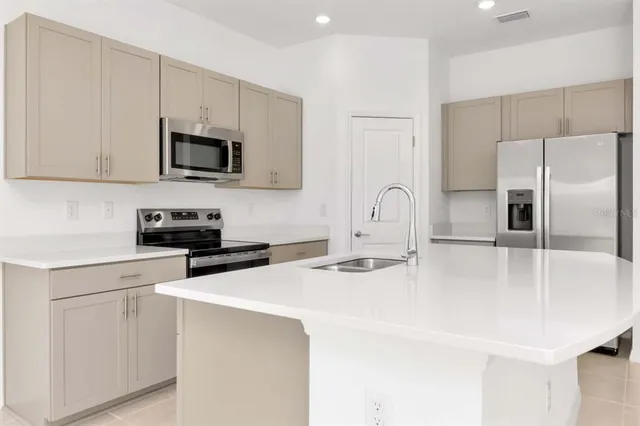 a kitchen with stainless steel appliances a stove microwave sink and refrigerator