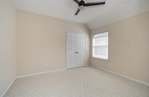 an empty room with a window and a ceiling fan