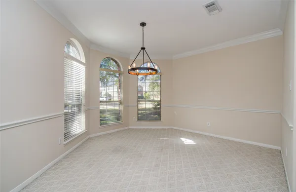 a view of an empty room with a window and a kitchen