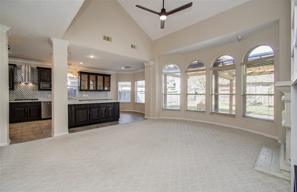 an empty room with windows and fireplace