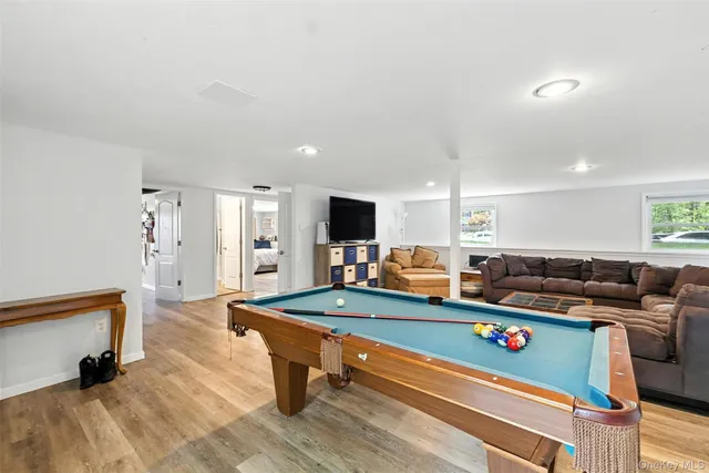 a living room with furniture pool table and a large window