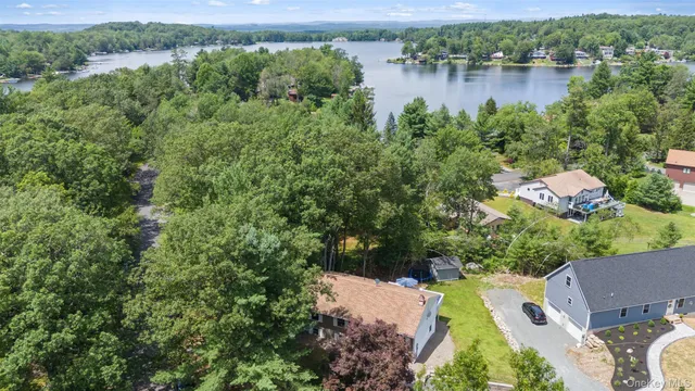 an aerial view of a house with a yard and lake view