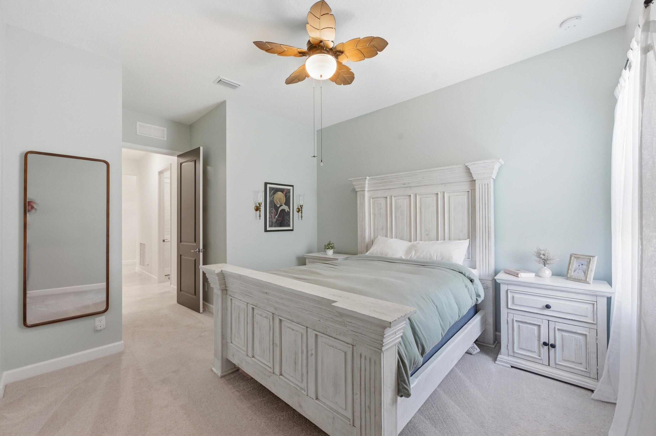 19230 Rolling Acres Road Loxahatchee, FL 33470 - Photo 15 of 58 a bedroom with a bed a chandelier and a dresser