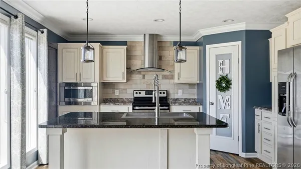 a kitchen with stainless steel appliances granite countertop a stove a sink and a refrigerator