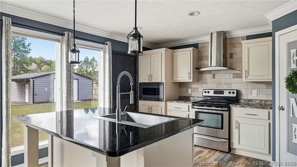 a kitchen with stainless steel appliances granite countertop a stove a sink and a refrigerator