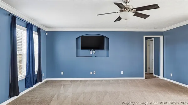 a view of an empty room with a window and a kitchen