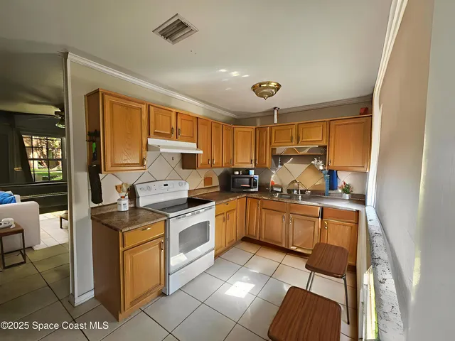 a kitchen with stainless steel appliances granite countertop a stove top oven a sink dishwasher and white cabinets