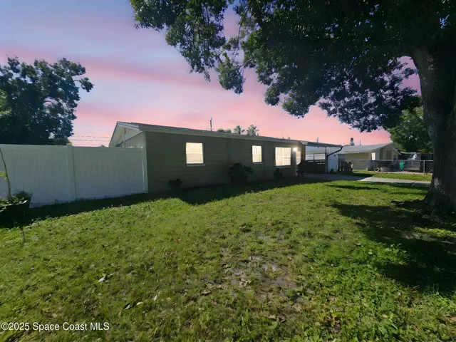 a view of house with yard and green space