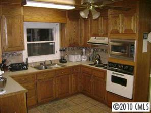 3129 Sikes Mill Road Monroe, NC 28110 - Photo 3 of 8 a kitchen with a sink and a stove top oven