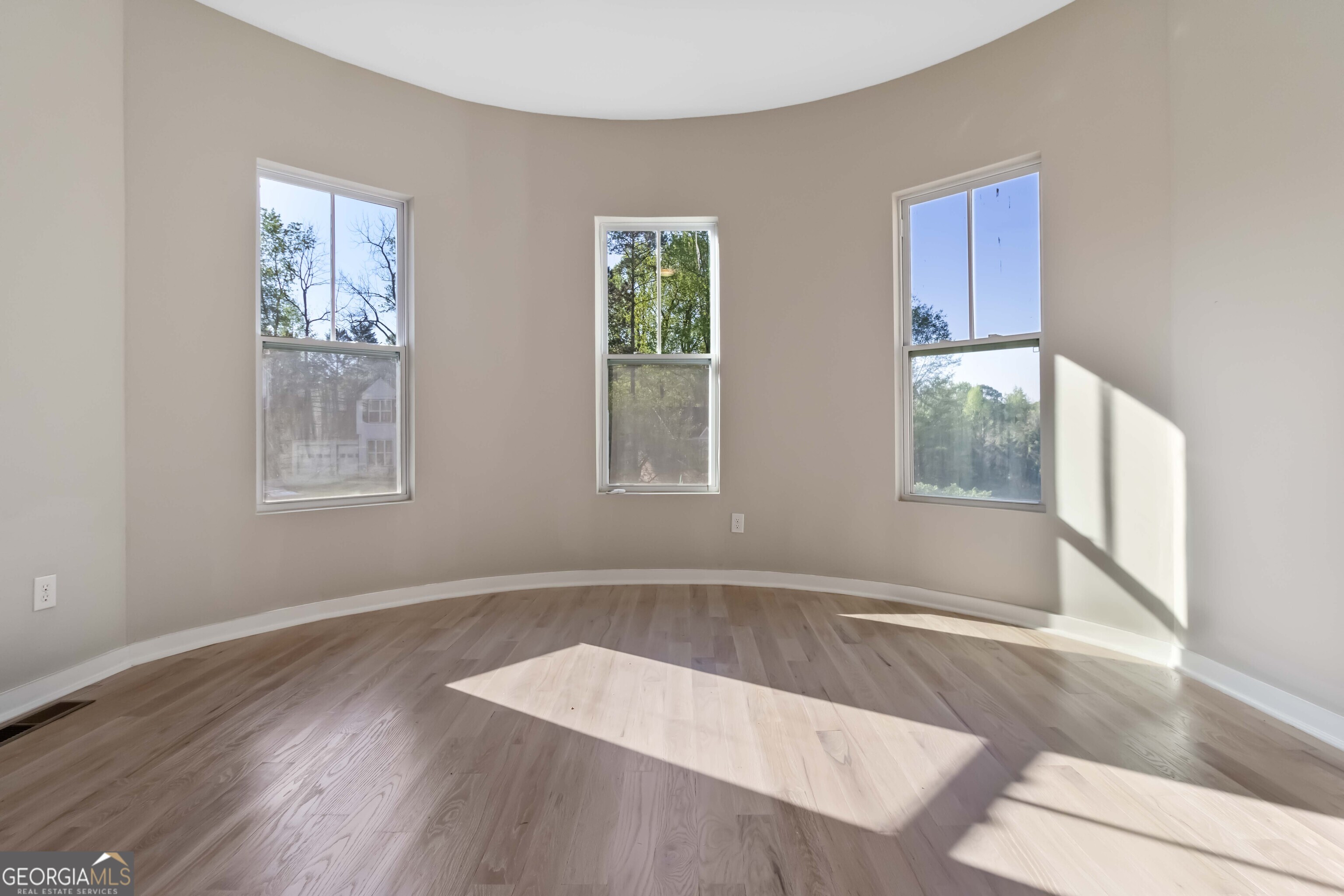 6960 Dockbridge Way Stone Mountain, GA 30087 - Photo 11 of 61 a view of an empty room with wooden floor and a window