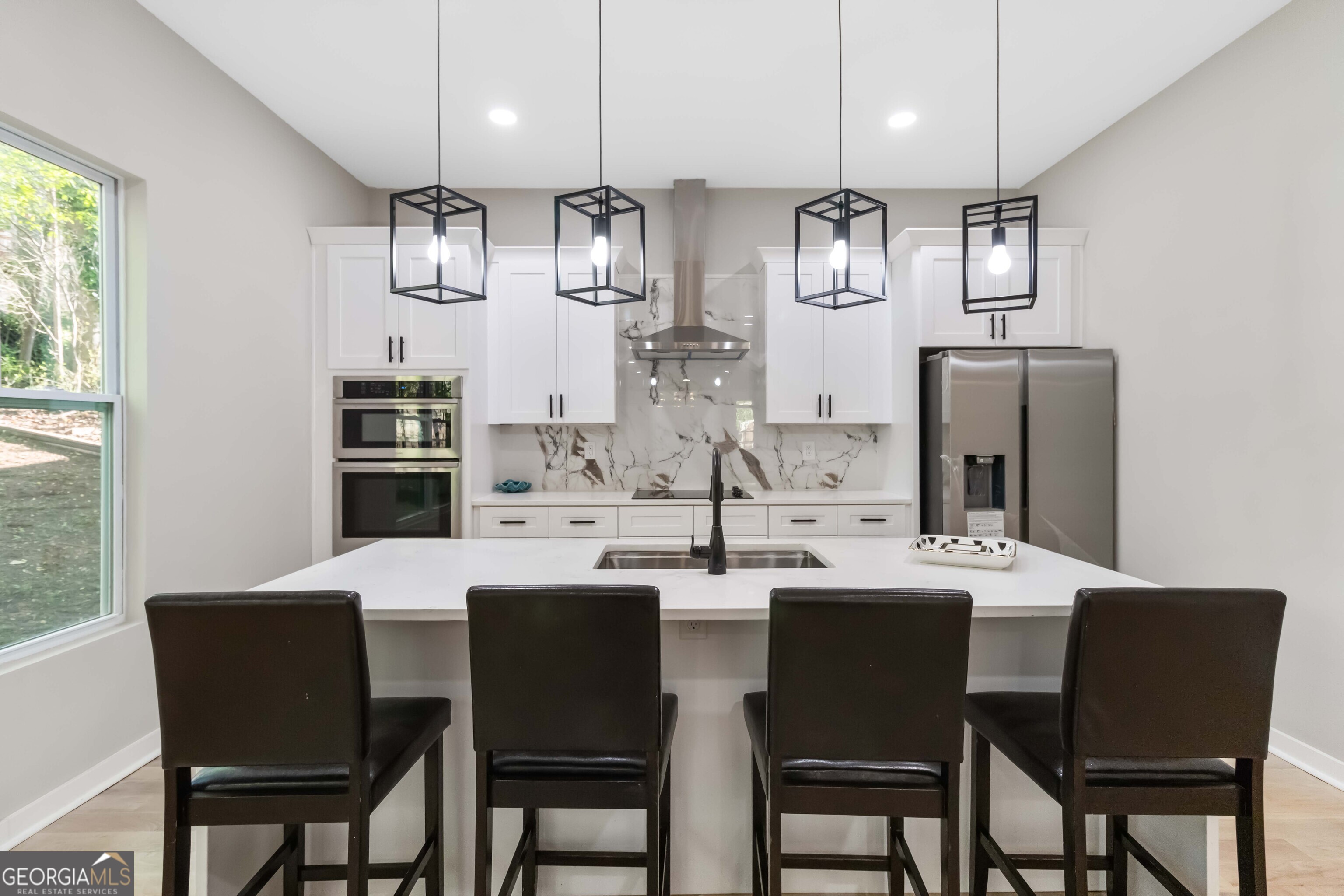 6960 Dockbridge Way Stone Mountain, GA 30087 - Photo 20 of 61 a kitchen with a dining table chairs stainless steel appliances and cabinets