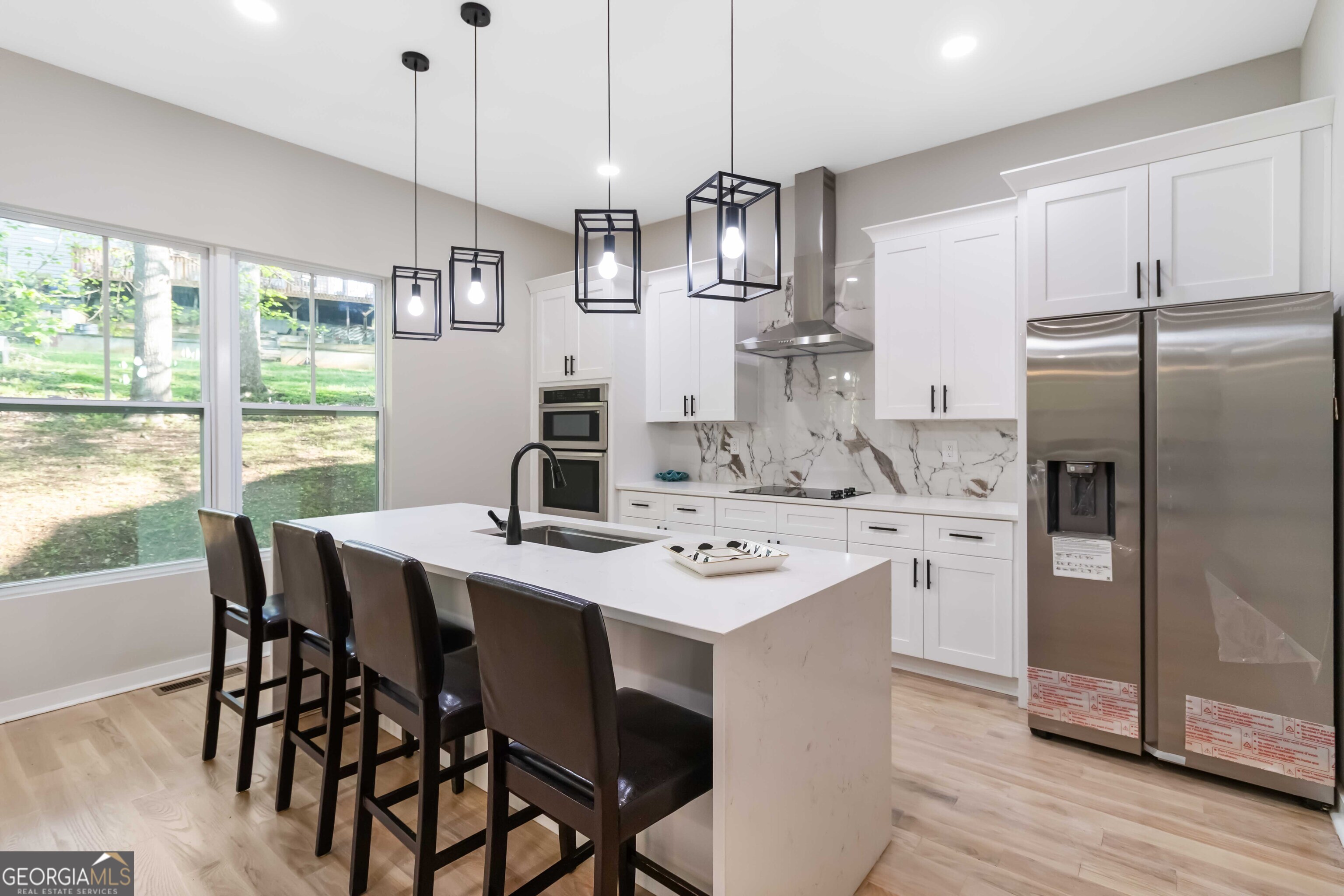 6960 Dockbridge Way Stone Mountain, GA 30087 - Photo 22 of 61 a kitchen with stainless steel appliances a dining table chairs refrigerator and sink