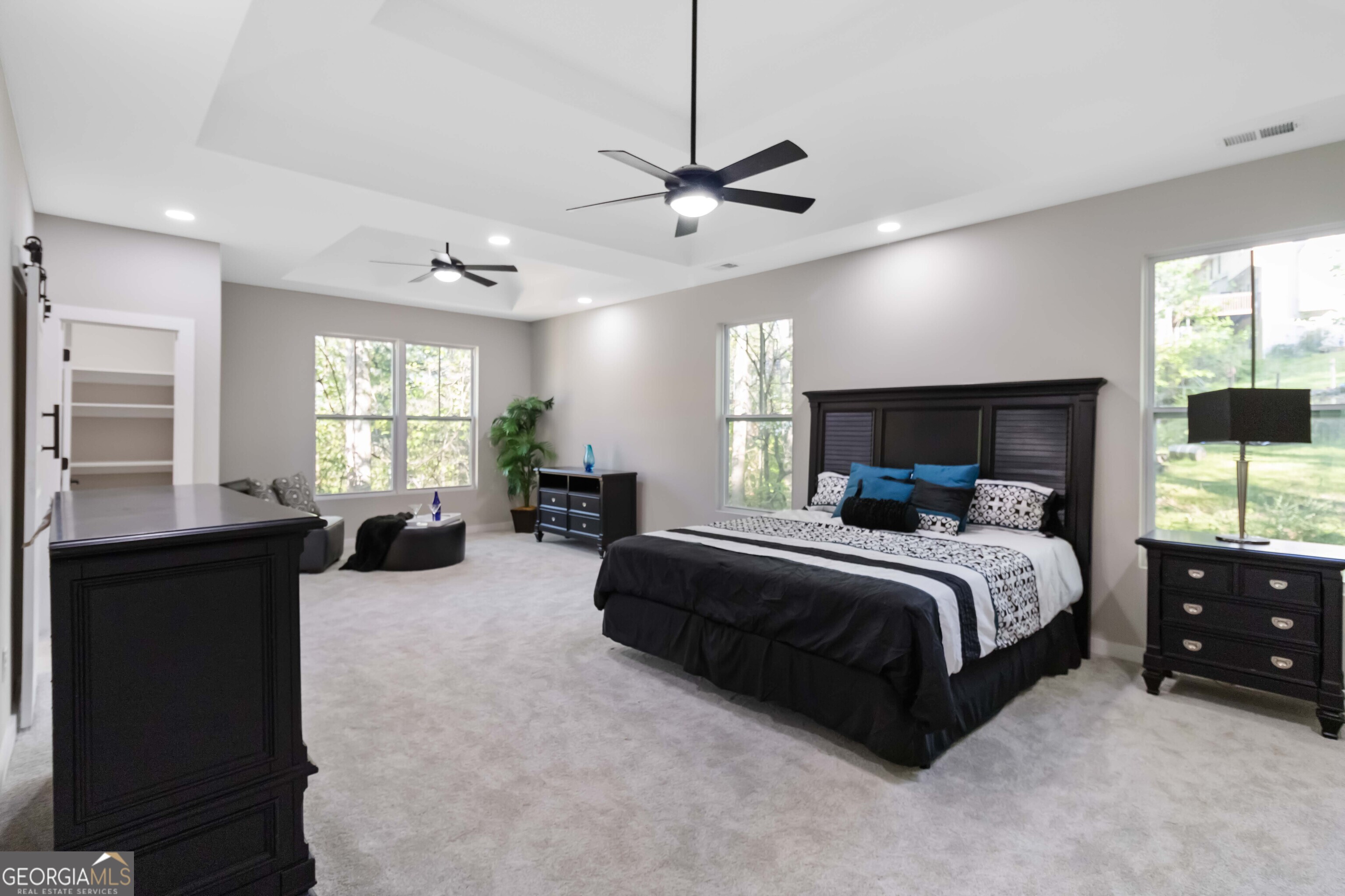 6960 Dockbridge Way Stone Mountain, GA 30087 - Photo 27 of 61 a spacious bedroom with a bed a couch and window
