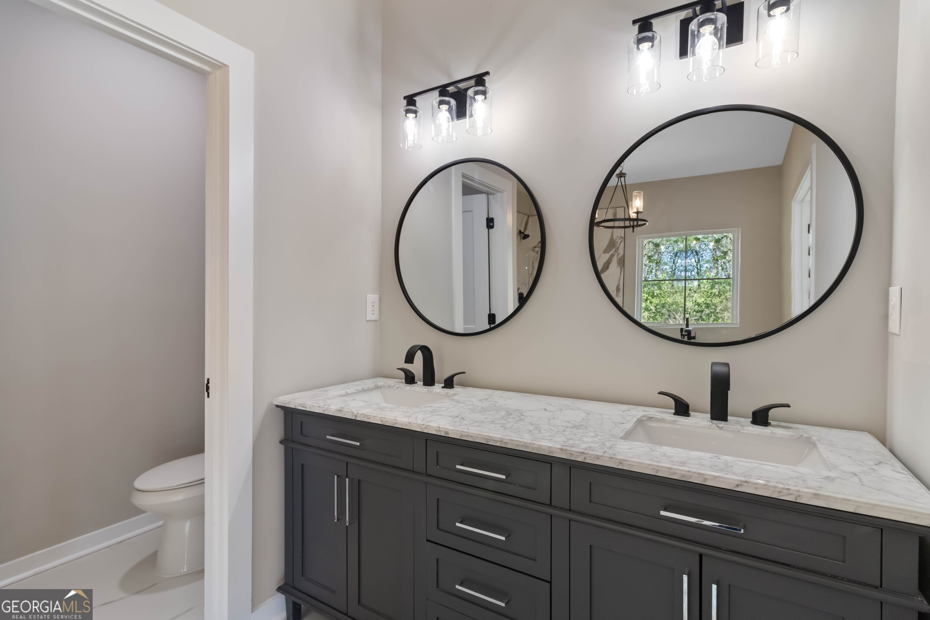 6960 Dockbridge Way Stone Mountain, GA 30087 - Photo 32 of 61 a bathroom with a granite countertop toilet a sink and a mirror