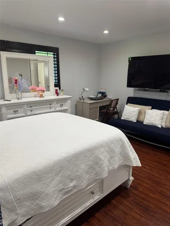 a bedroom with a bed and a flat screen tv