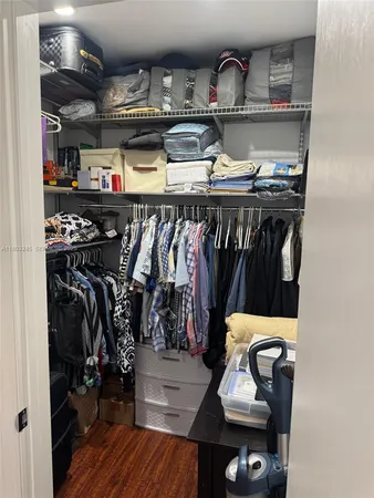 a view of walk in closet with clothes and shoes