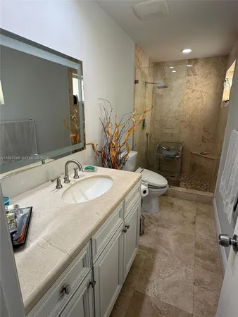 a bathroom with a granite countertop sink a toilet and a mirror