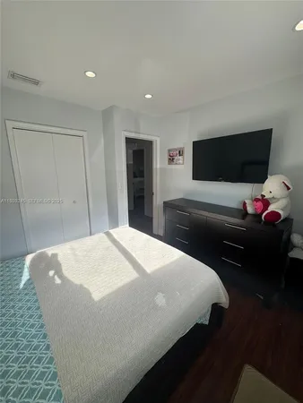 a bedroom with a bed and a flat screen tv