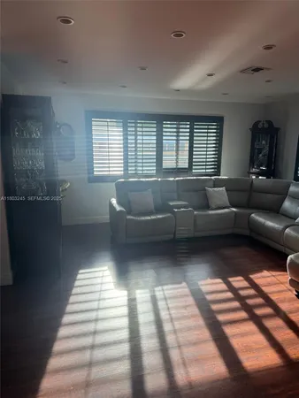 a living room with furniture and a hard wood floor