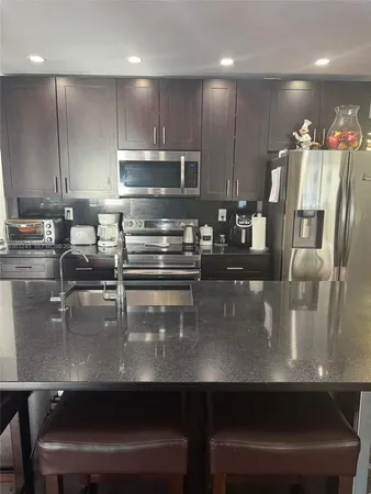 a kitchen with kitchen island counter space a sink appliances and cabinets