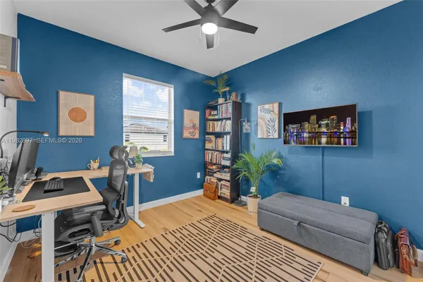 a living room with furniture a desk and chair with a bookshelf