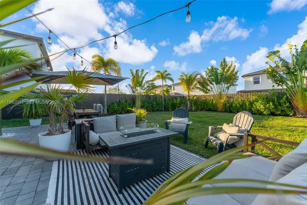 a view of a patio with couches and table and chairs under an umbrella