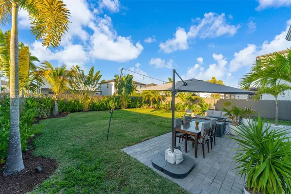 a view of a patio with table and chairs potted plants with palm trees