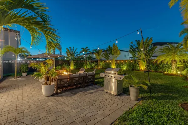 a backyard of a house with barbeque oven table and chairs