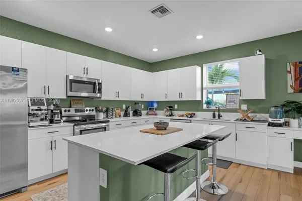 a kitchen with a stove a sink a dining table and chairs