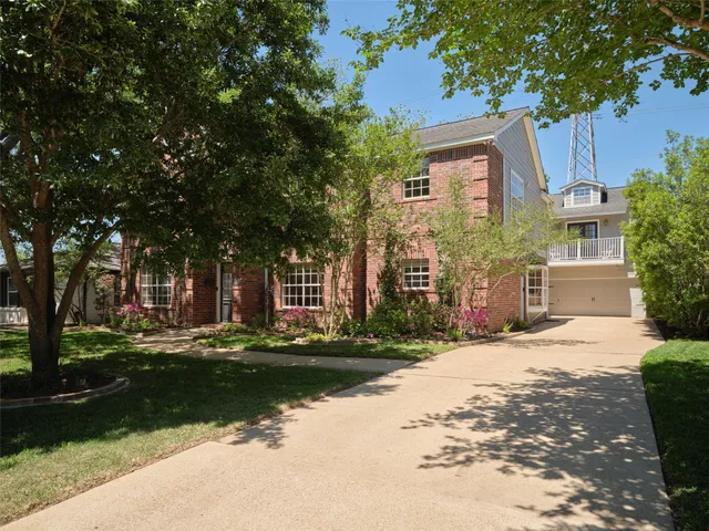 a front view of a house with a yard and trees