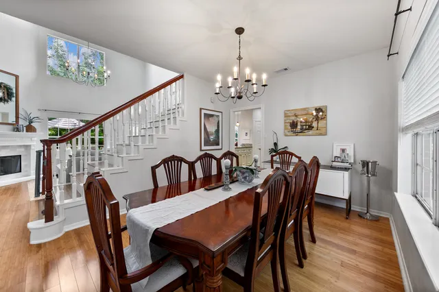 a view of a dining room with furniture a chandelier and wooden floor