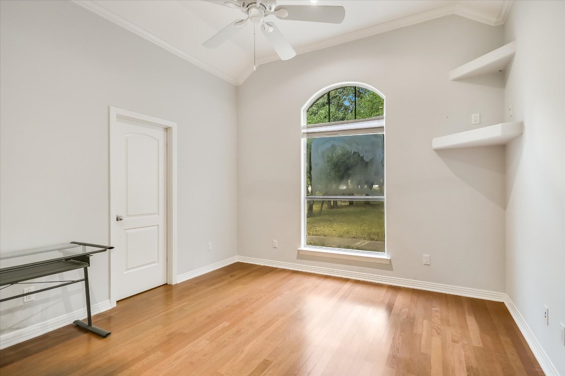 112 Twin Saddles Dripping Springs, TX 78620 - Photo 13 of 29 an empty room with wooden floor fan and windows
